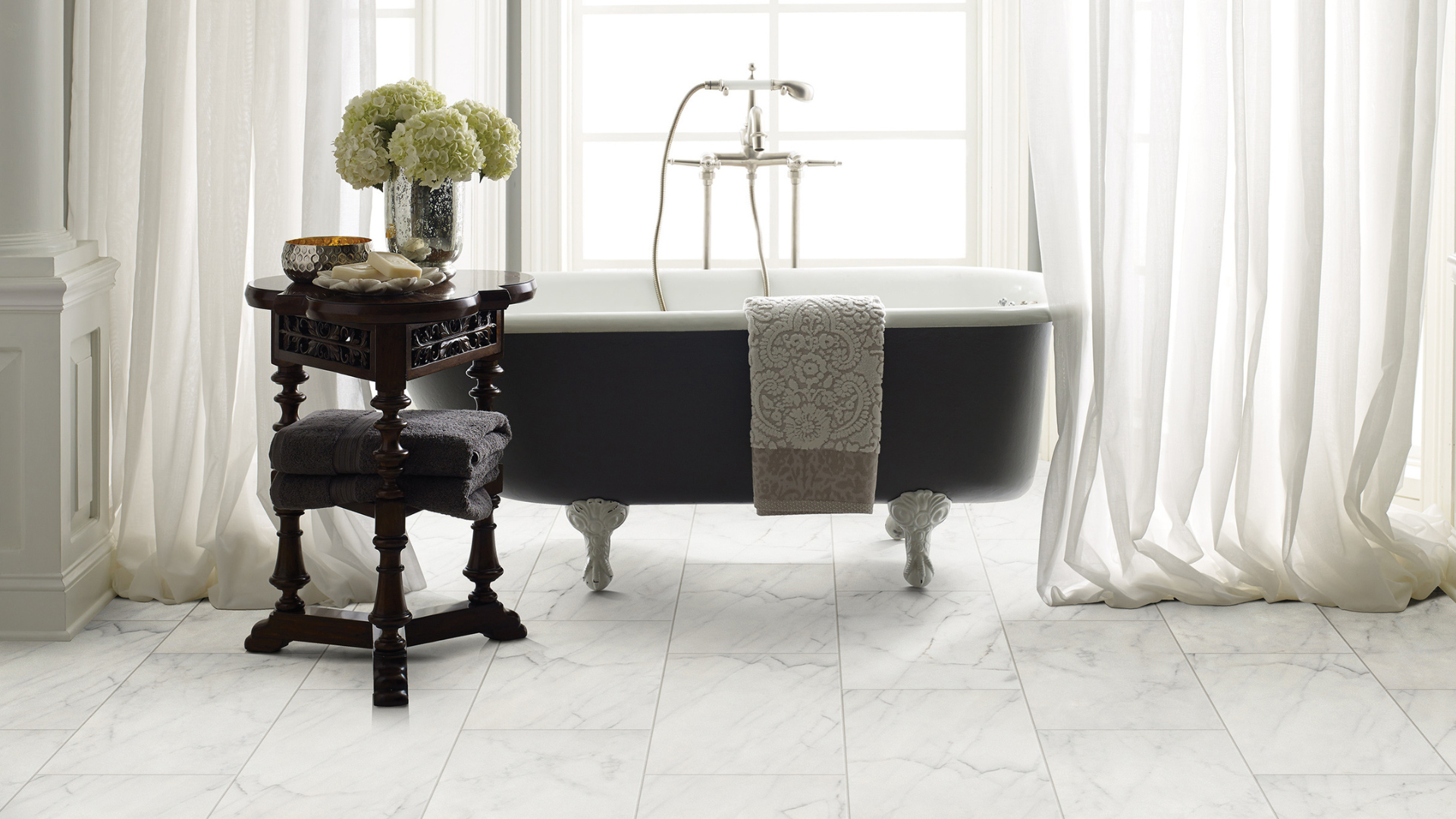 stone marble look tile flooring in bathroom with clawfoot tub and curtains
